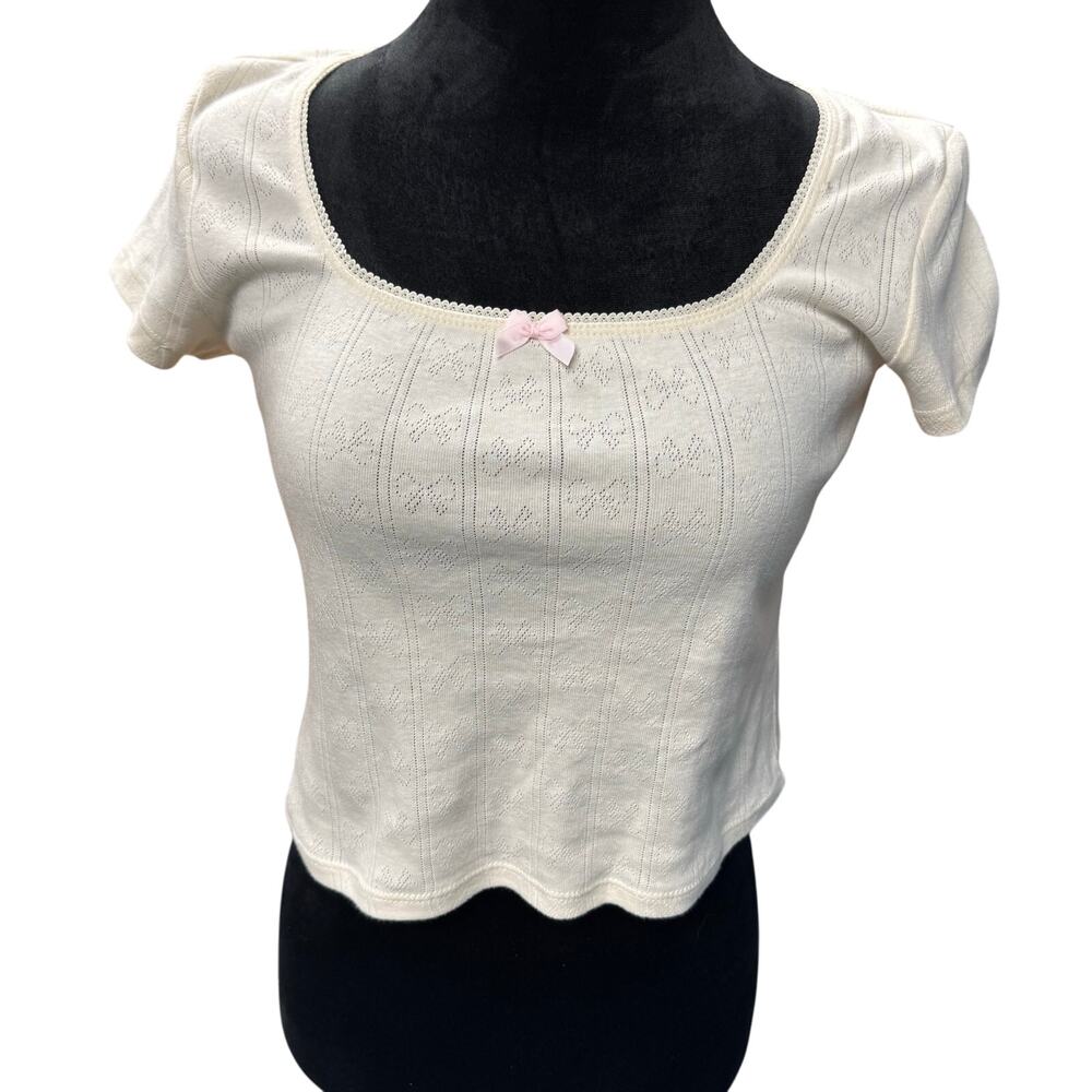 Just Polly cropped white shirt with bow pattern throughout and pink bow